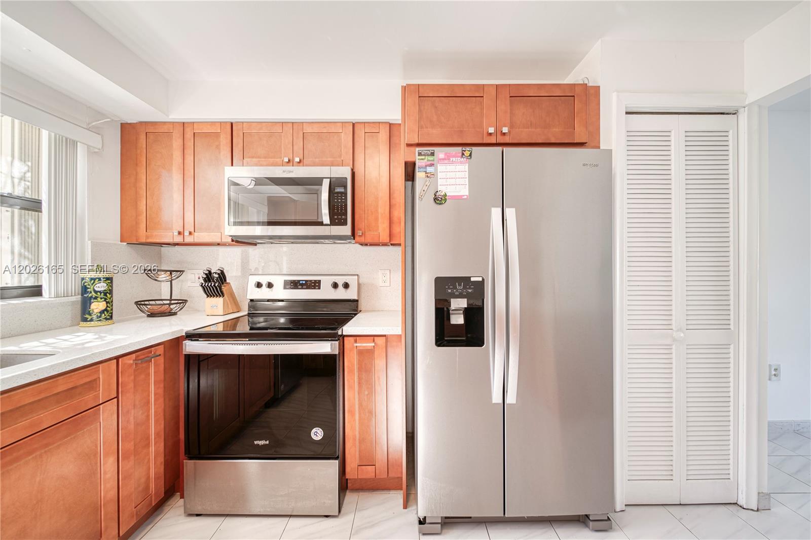 13337 Southwest 64th Lane Miami, FL 33183 - Photo 13 of 36 a kitchen with a refrigerator sink stove and microwave
