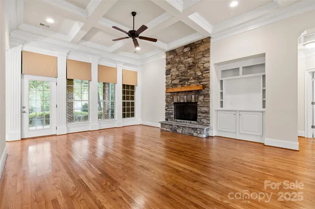 a view of empty room with wooden floor and fireplace