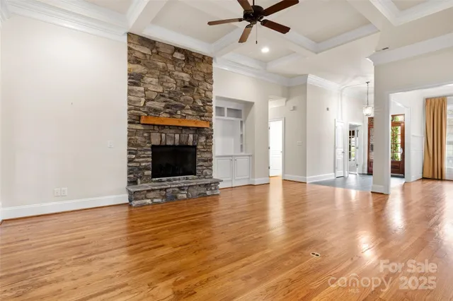 a view of a livingroom with wooden floor and a ceiling fan
