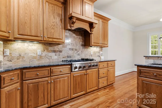 a kitchen with stainless steel appliances granite countertop a sink stove and cabinets