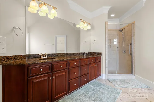 a bathroom with a granite countertop sink a large mirror and a shower