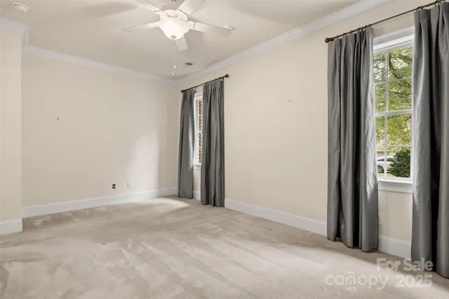 a view of a livingroom with a chandelier fan and a window