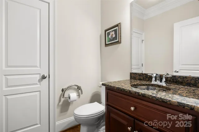 a bathroom with a granite countertop toilet sink and mirror
