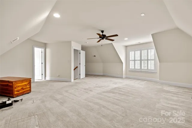an empty room with windows and ceiling fan