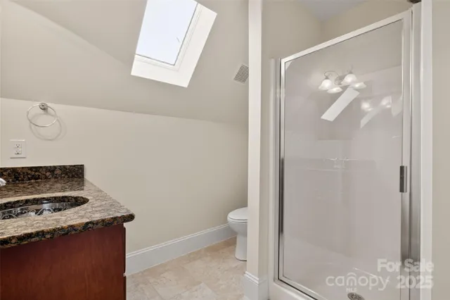 a bathroom with a granite countertop sink a toilet and a mirror
