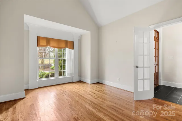 an empty room with wooden floor and a window