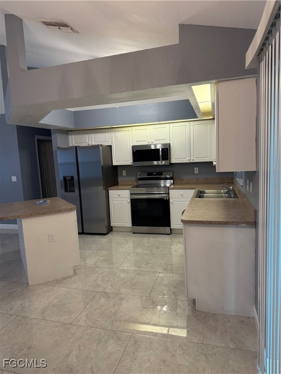 3509 8th Street Southwest Lehigh Acres, FL 33976 - Photo 5 of 14 a kitchen with stainless steel appliances a stove a sink and a refrigerator