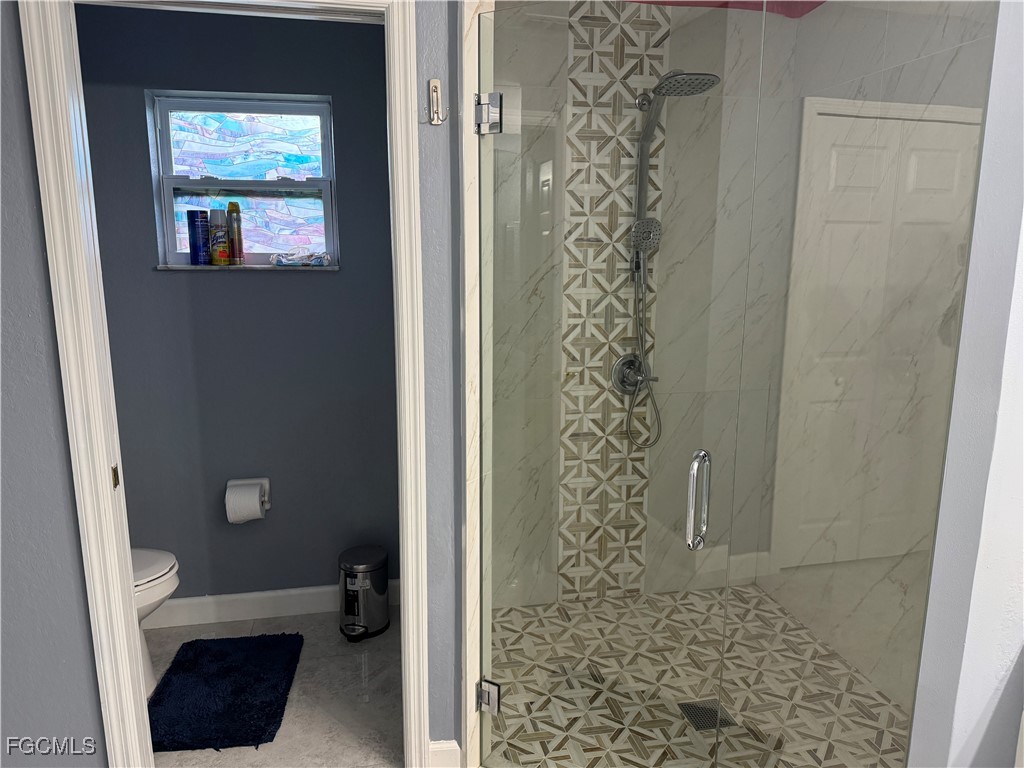 3509 8th Street Southwest Lehigh Acres, FL 33976 - Photo 10 of 14 a bathroom with a toilet and a shower