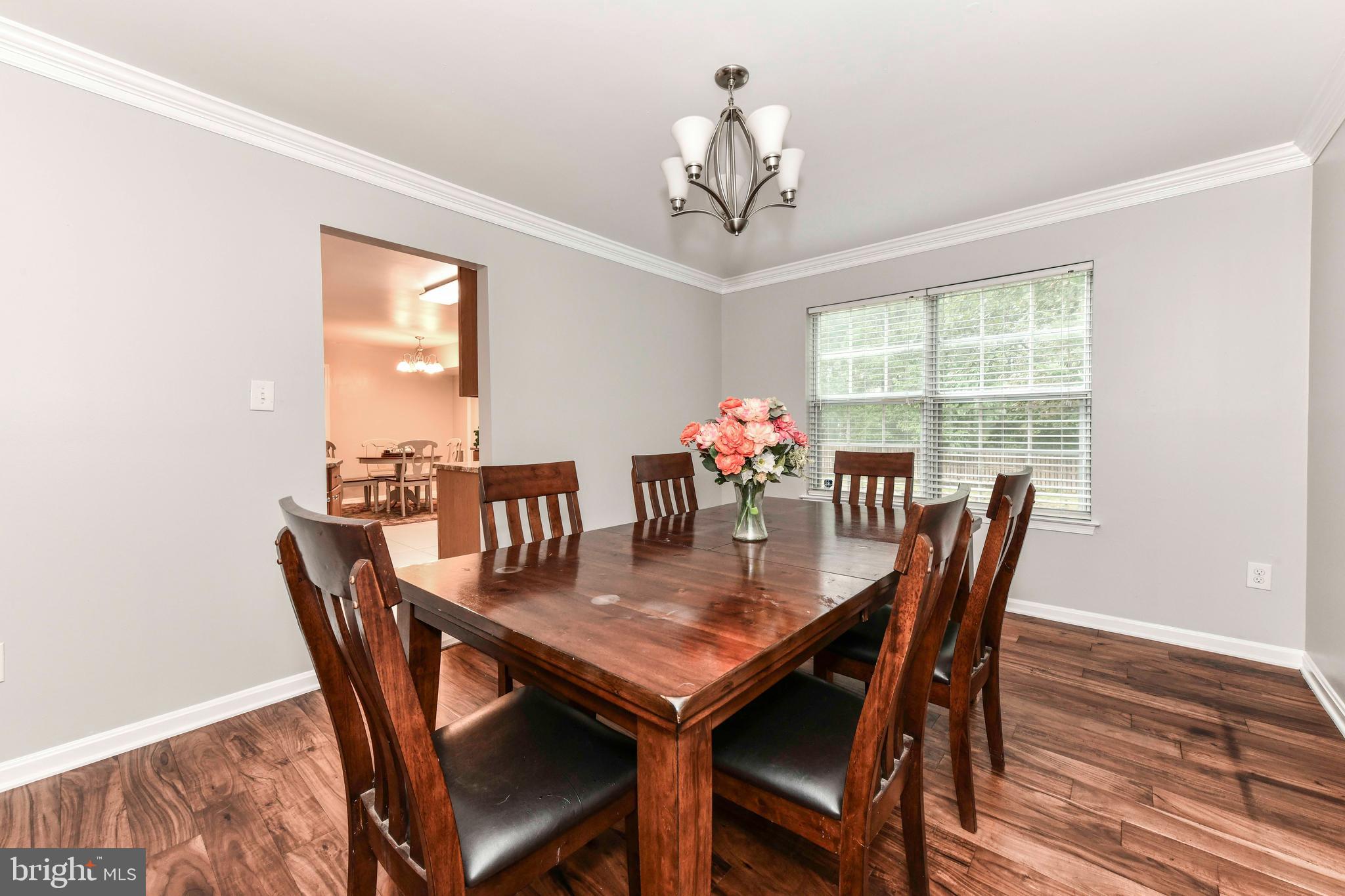 5500 Hampton Forest Way Clifton, VA 20124 - Photo 12 of 49 a view of a dining room with furniture a chandelier and wooden floor
