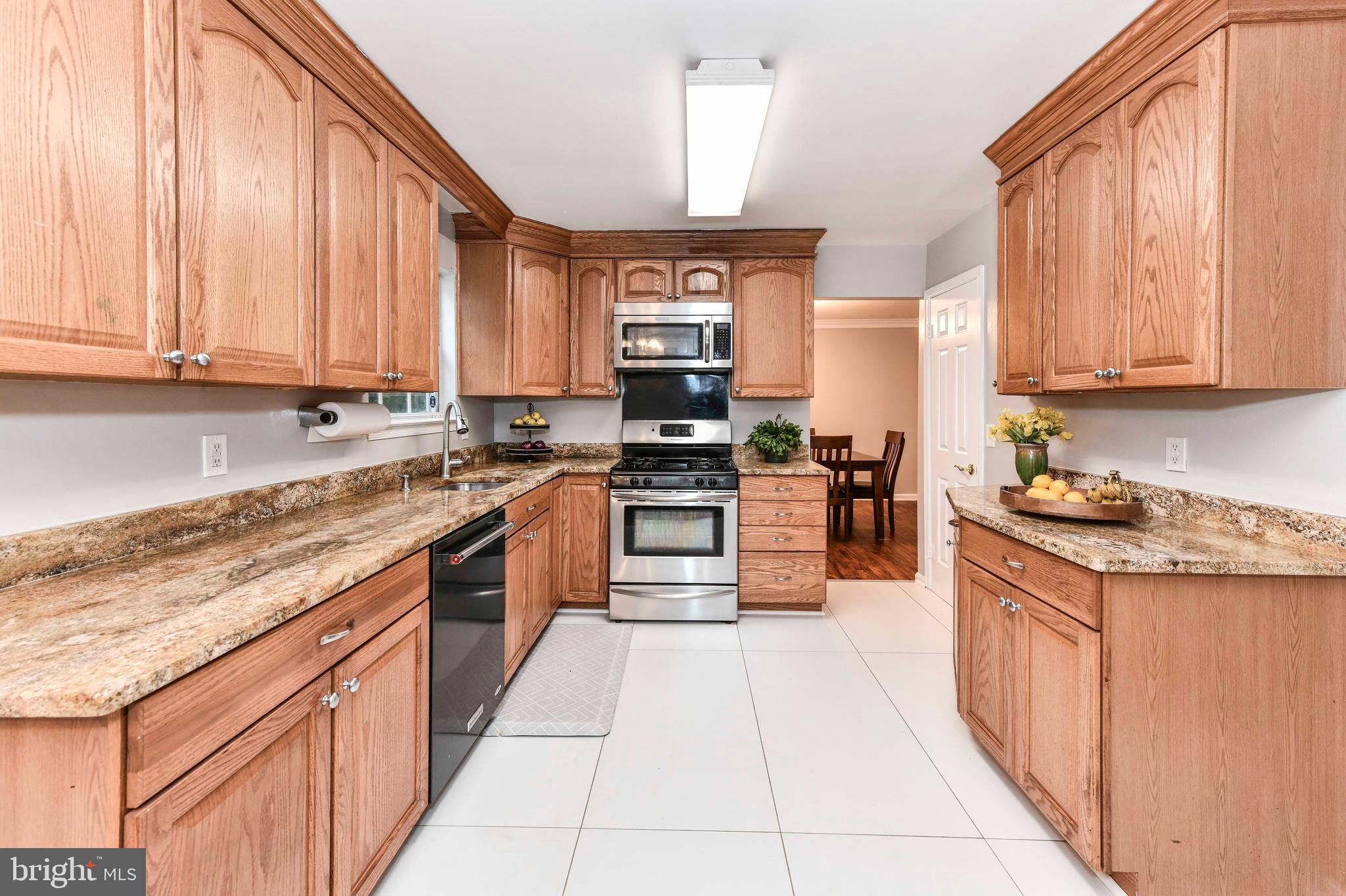 5500 Hampton Forest Way Clifton, VA 20124 - Photo 15 of 49 a kitchen with stainless steel appliances granite countertop a stove top oven a sink and dishwasher a refrigerator with wooden cabinets