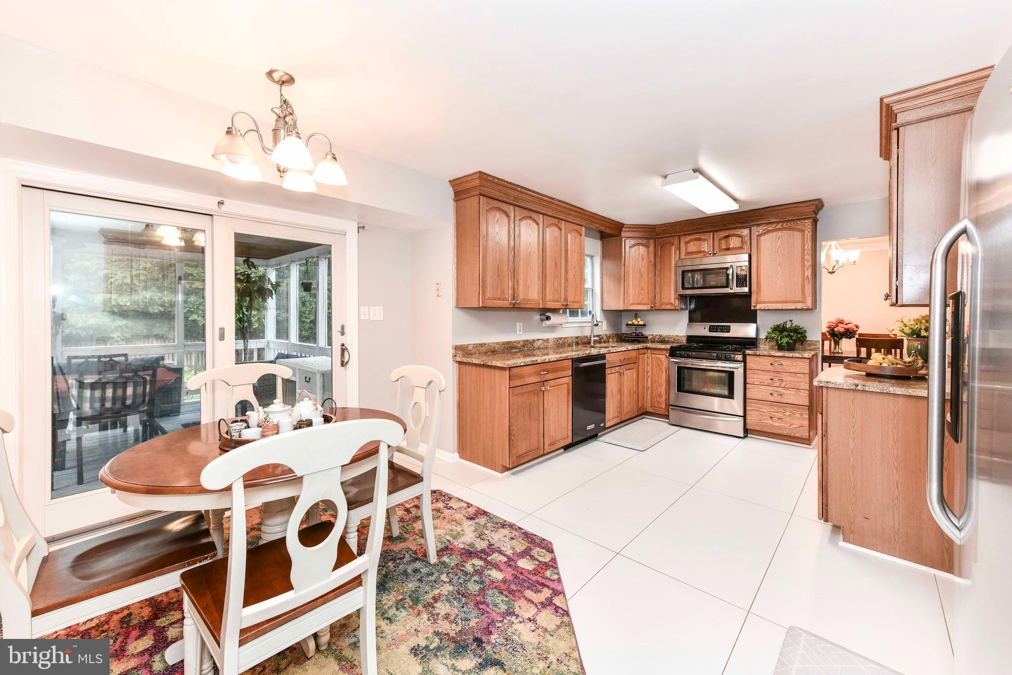 5500 Hampton Forest Way Clifton, VA 20124 - Photo 17 of 49 a kitchen with stainless steel appliances granite countertop a stove a sink dishwasher and a refrigerator with wooden floor