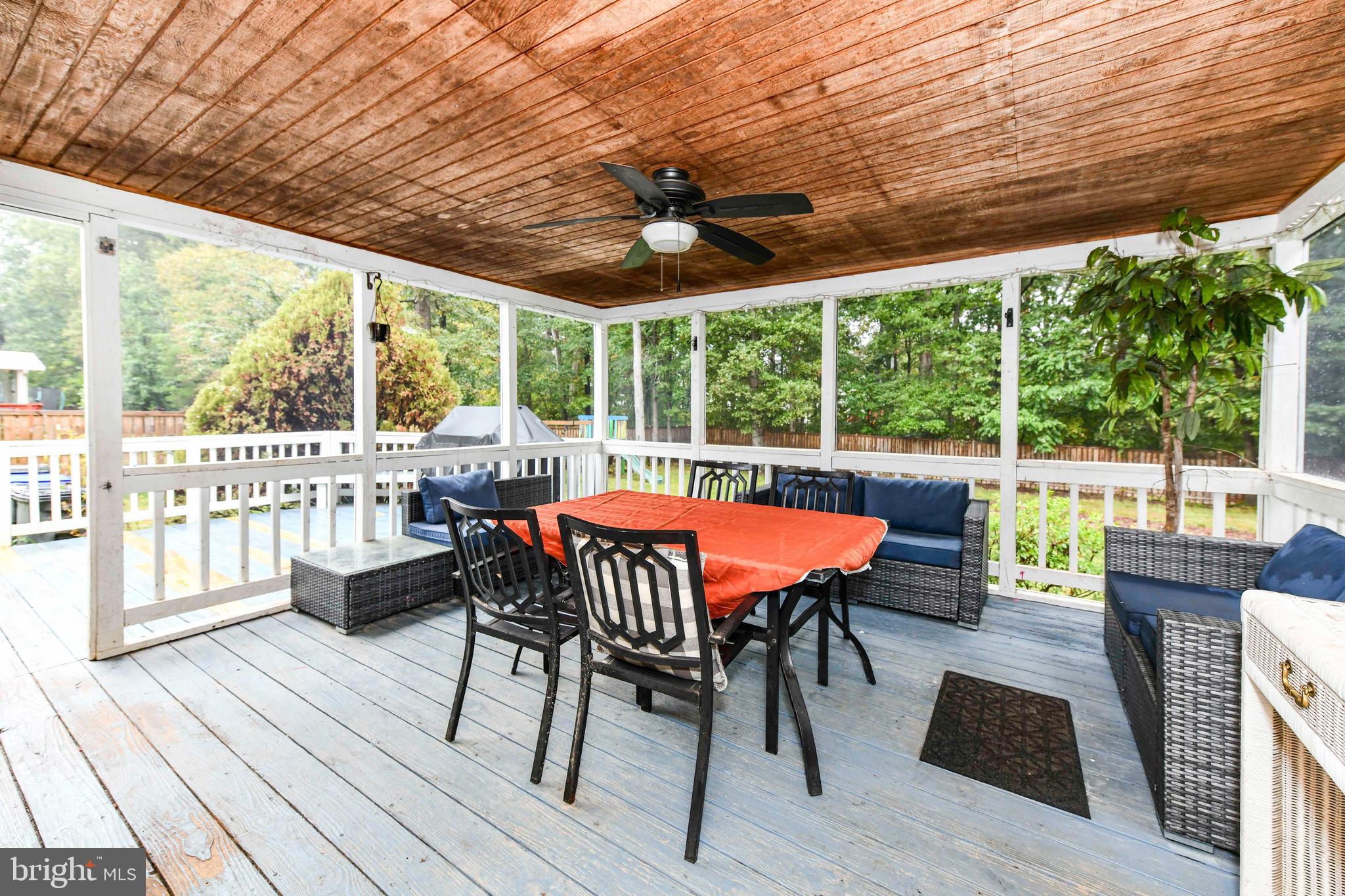 5500 Hampton Forest Way Clifton, VA 20124 - Photo 43 of 49 a view of a patio with table and chairs potted plants with wooden floor and fence