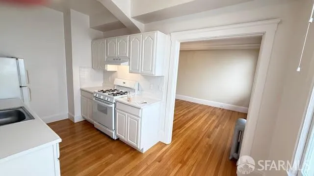 a kitchen with white cabinets and appliances