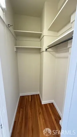 a view of a room with wooden floor and white walls
