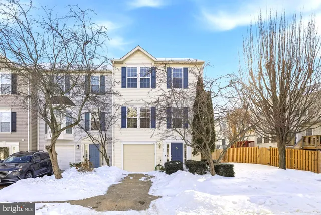 a front view of a house with a yard covered in snow