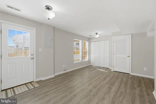 a view of an empty room with wooden floor