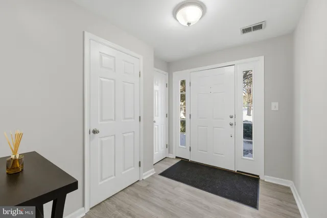 an empty room with wooden floor cabinet and hallway