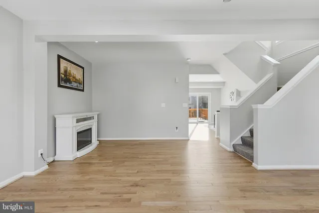 a view of a livingroom with wooden floor and a fireplace