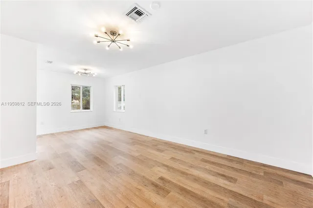 a view of a room with wooden floor and a ceiling fan
