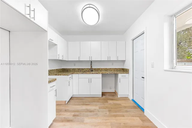 a view of a kitchen with white cabinets and sink