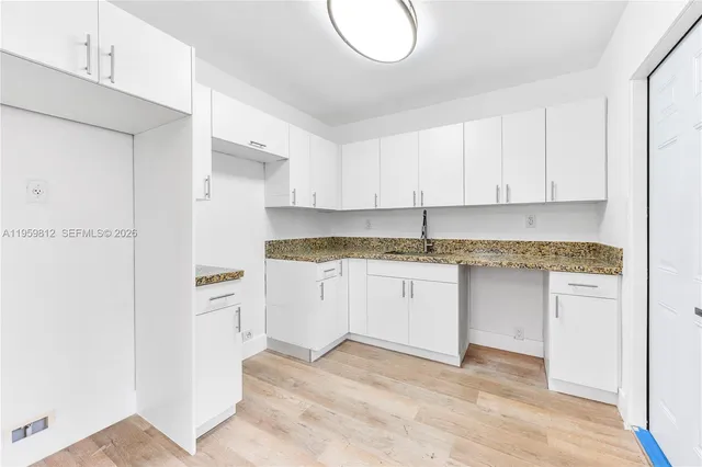 a kitchen with granite countertop white cabinets and stainless steel appliances