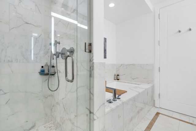 a bathroom with a bath tub with a shower