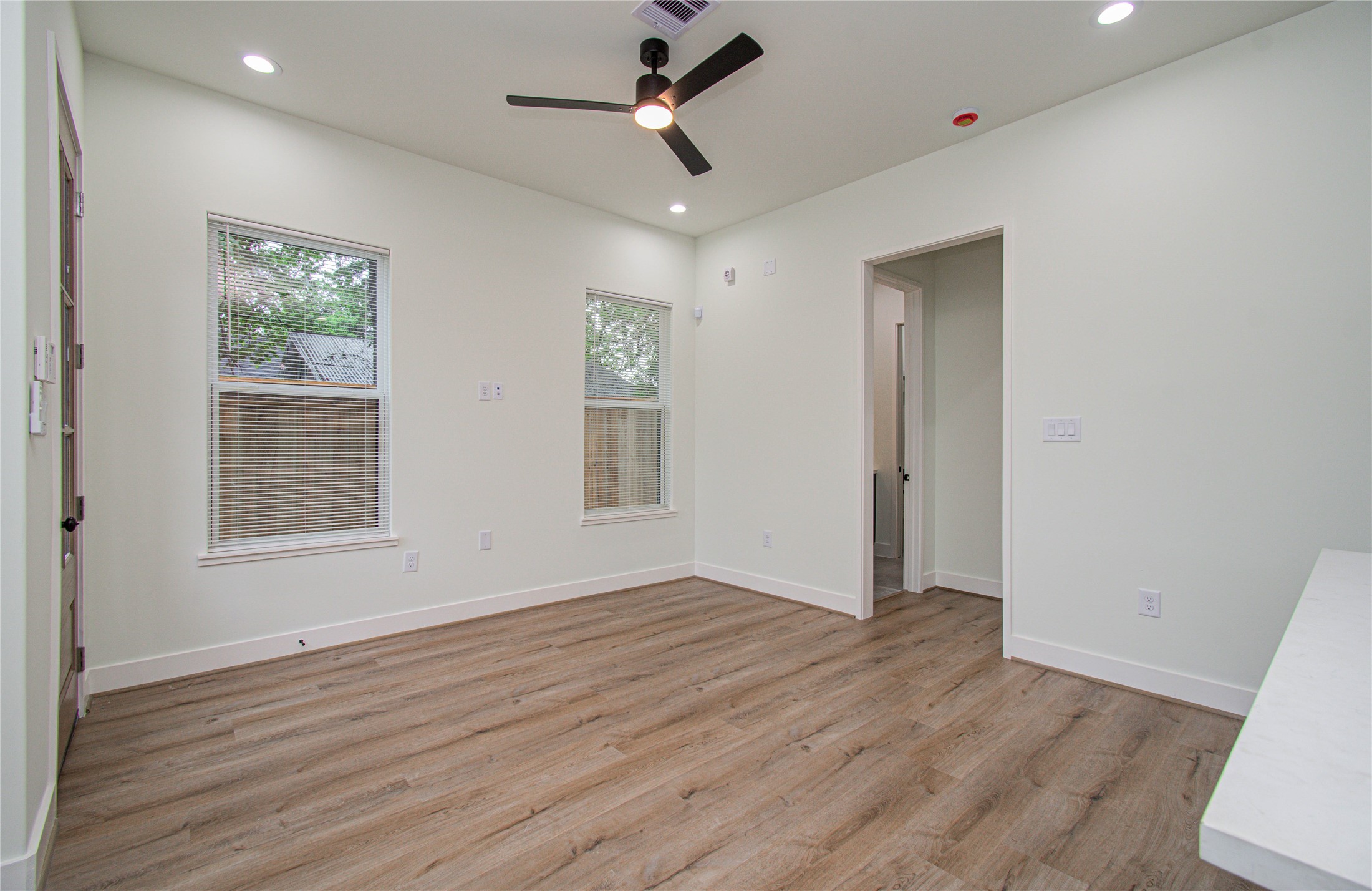 4603 Edison Street, Unit A Houston, TX 77009 - Photo 5 of 23 an empty room with wooden floor ceiling fan and windows