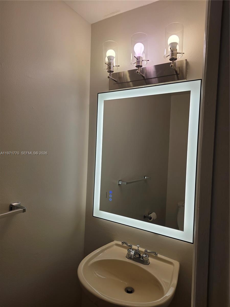 12490 Southwest 54th Street, Unit 12490 Miramar, FL 33027 - Photo 4 of 7 a bathroom with a sink and a mirror