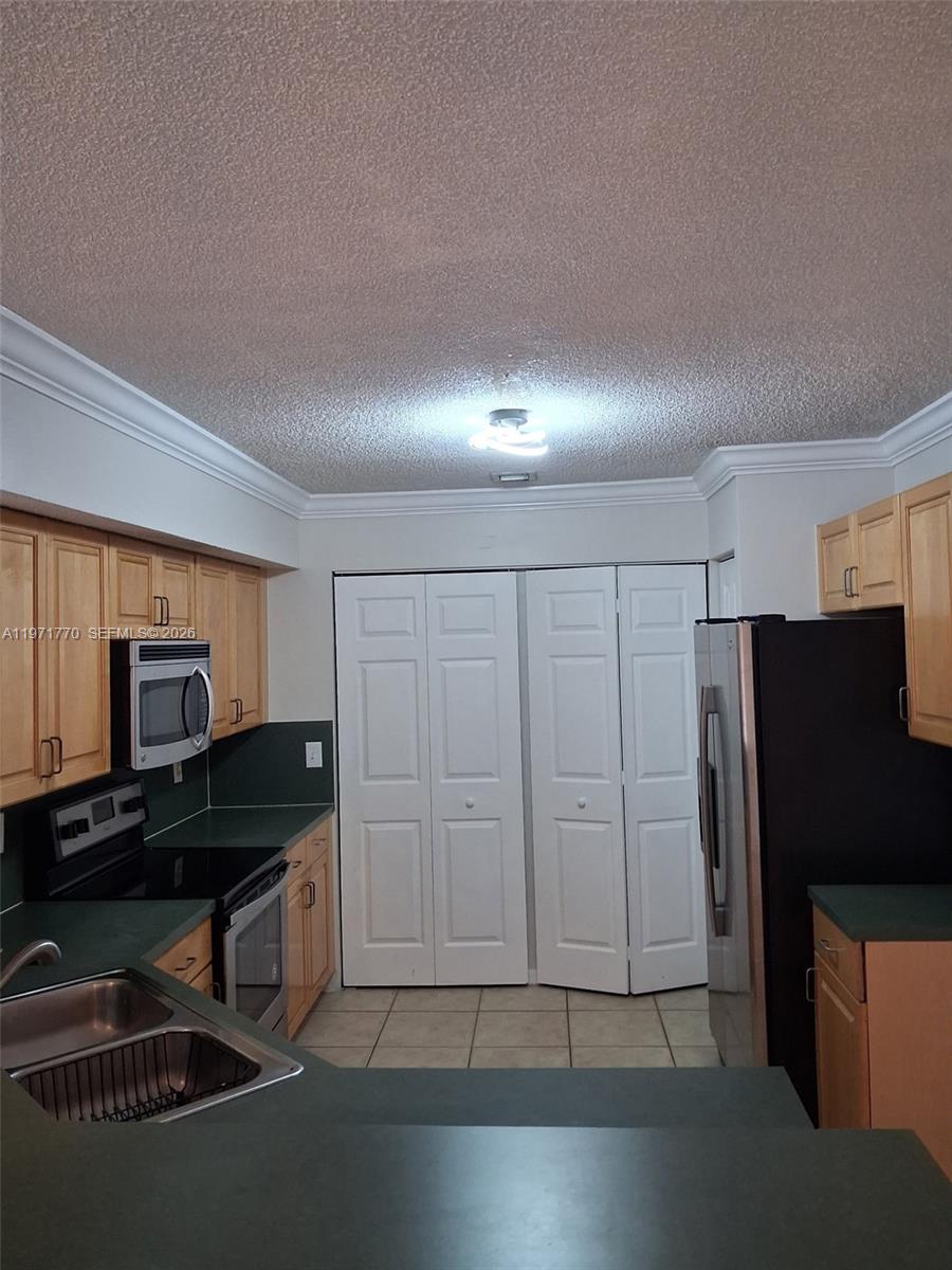 12490 Southwest 54th Street, Unit 12490 Miramar, FL 33027 - Photo 7 of 7 a kitchen with a refrigerator a stove and a sink