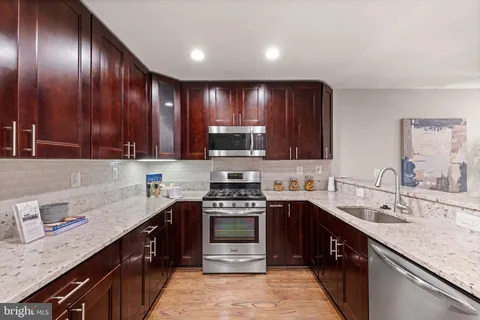 a kitchen with a sink stove top oven and cabinets