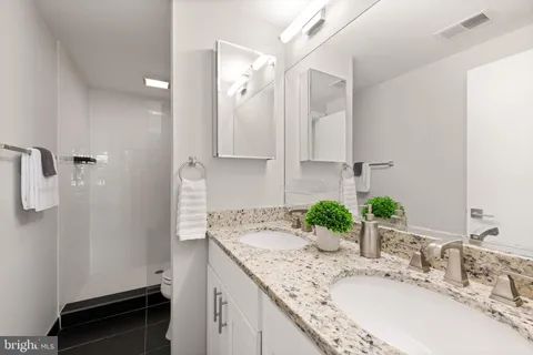 a bathroom with a granite countertop sink and a mirror