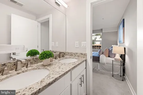 a bathroom with a granite countertop sink and a mirror