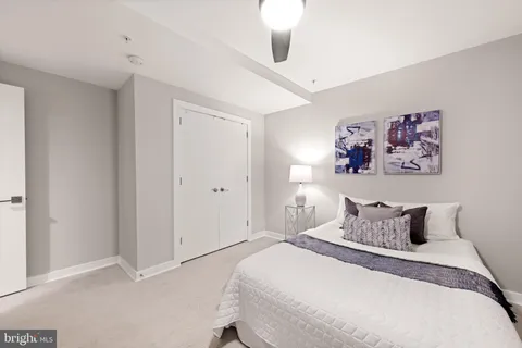 a bedroom with a bed and painting on the wall