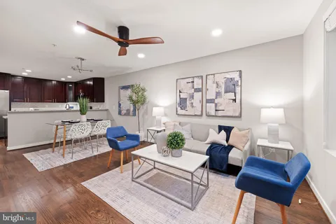 a living room with furniture and a view of kitchen