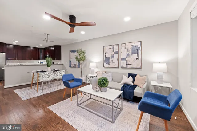 a living room with furniture and a view of kitchen