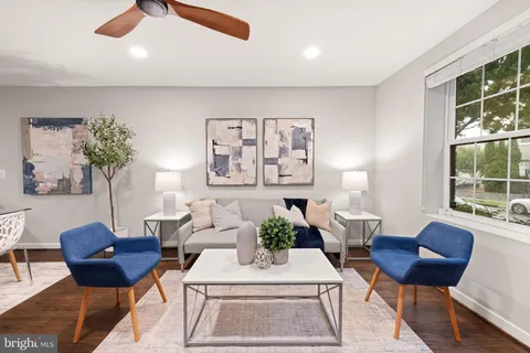 a living room with furniture a table and chair with a large window