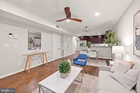 a living room with furniture and a wooden floor