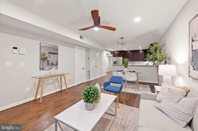 a living room with furniture and a wooden floor