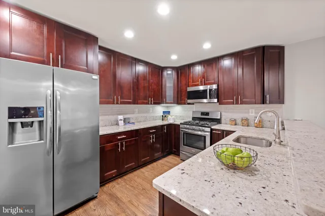 a kitchen with granite countertop stainless steel appliances and wooden cabinets