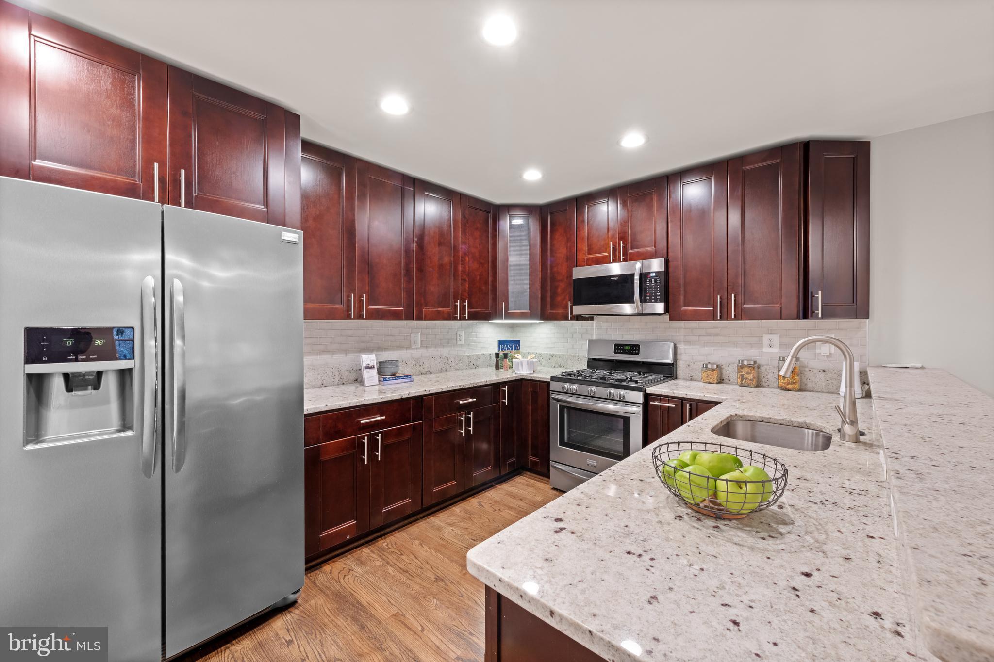 1812 D Street Northeast, Unit 1 Washington, DC 20002 - Photo 10 of 31 a kitchen with granite countertop stainless steel appliances and wooden cabinets