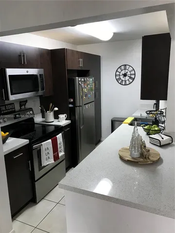 a kitchen with a refrigerator and a sink