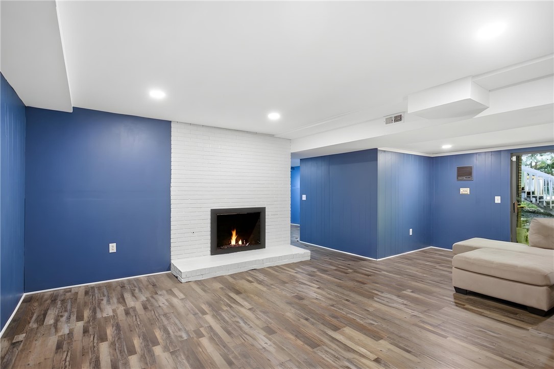 311 Cumberland Way Anderson, SC 29621 - Photo 30 of 44 Warm wood-look flooring and a cozy fireplace create an inviting ambiance in this versatile living space.