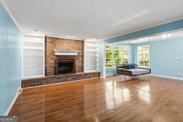 a view of a livingroom with wooden floor and a fireplace