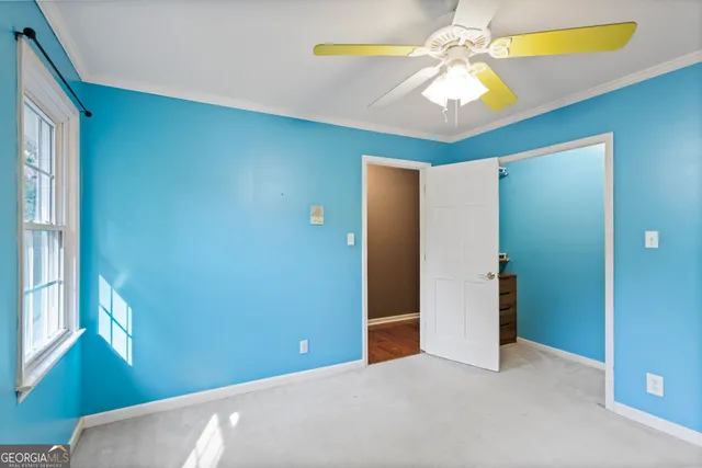 a view of an empty room with a window and a ceiling fan