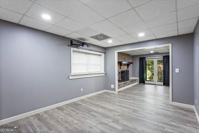 a view of a yard with plants and large trees