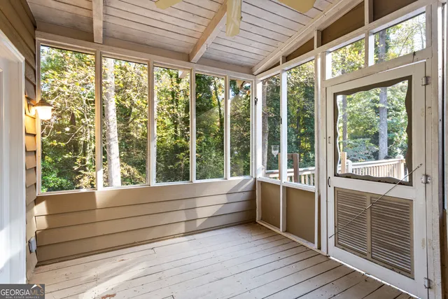 a view of an empty room with wooden floor fireplace and a window