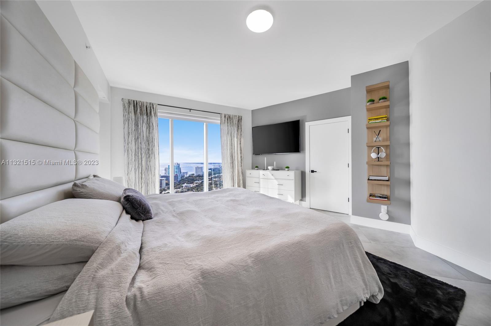 60 Southwest 13th Street, Unit 3600 Miami, FL 33130 - Photo 23 of 43 a bedroom with a bed and a flat tv screen on the dresser