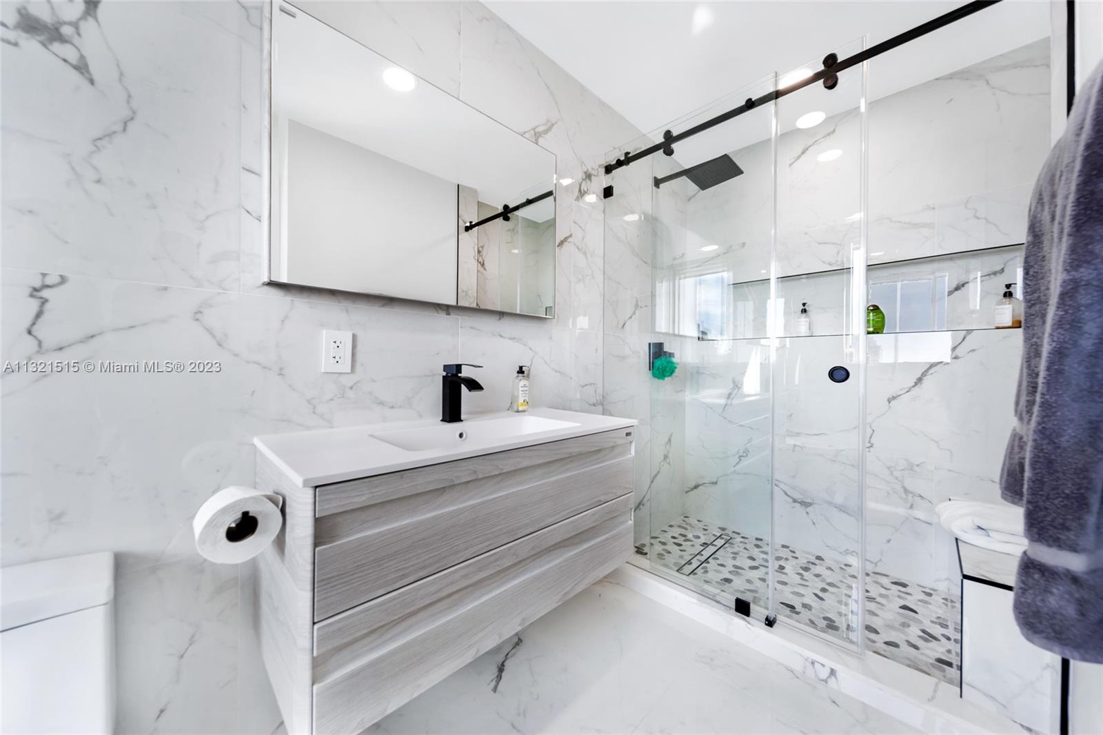 60 Southwest 13th Street, Unit 3600 Miami, FL 33130 - Photo 31 of 43 a bathroom with a sink mirror and shower