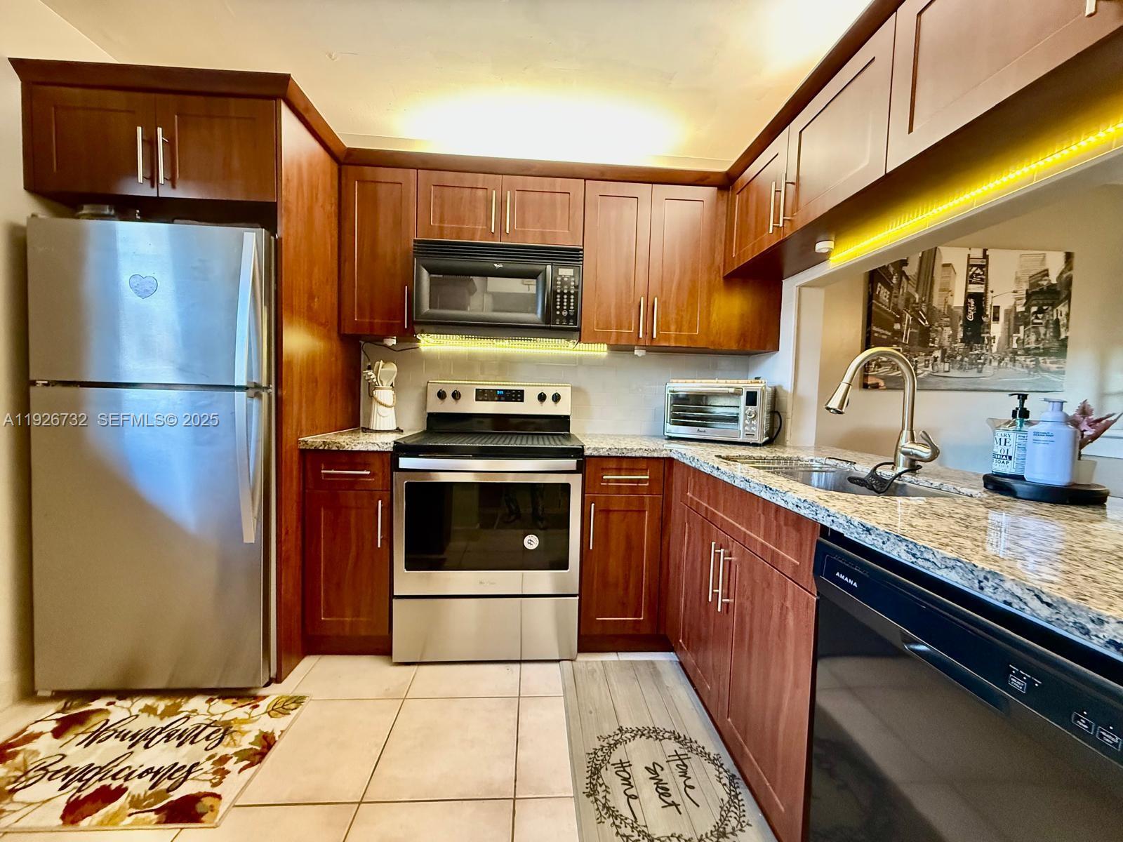 10616 Northwest 10th Street, Unit 104 Pembroke Pines, FL 33026 - Photo 12 of 47 a kitchen with stainless steel appliances granite countertop a refrigerator sink and stove