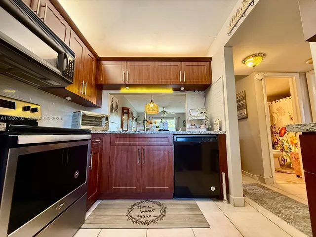 a kitchen with stainless steel appliances granite countertop a refrigerator and a stove